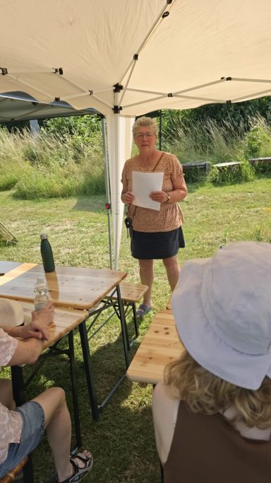 Vortragende unter einem Sonnenschutz